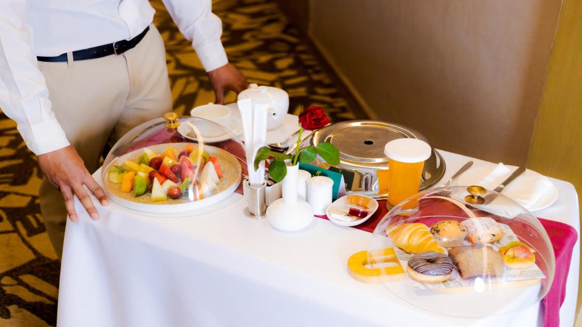 a man standing next to a table with food on it at Holiday Inn New Delhi Aerocity by IHG in New Delhi