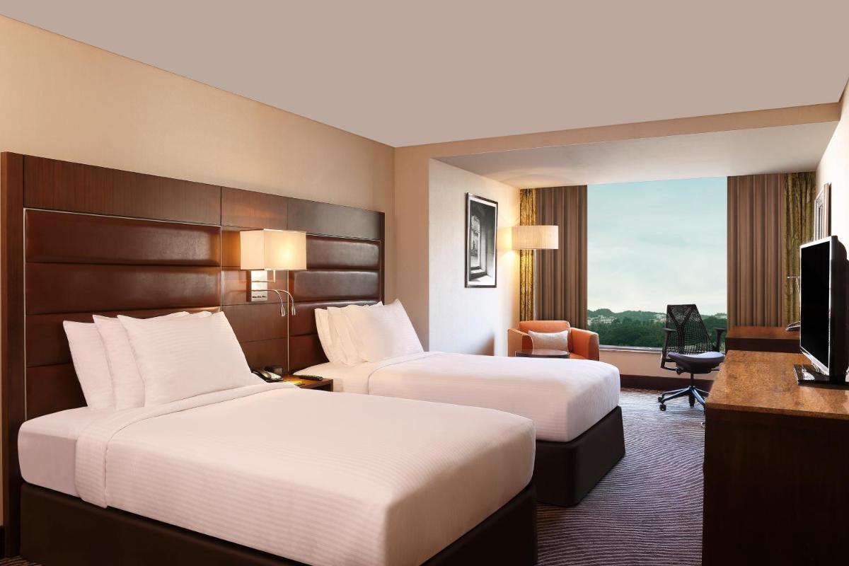 a hotel room with two beds and a television at Hilton Garden Inn, Trivandrum in Trivandrum