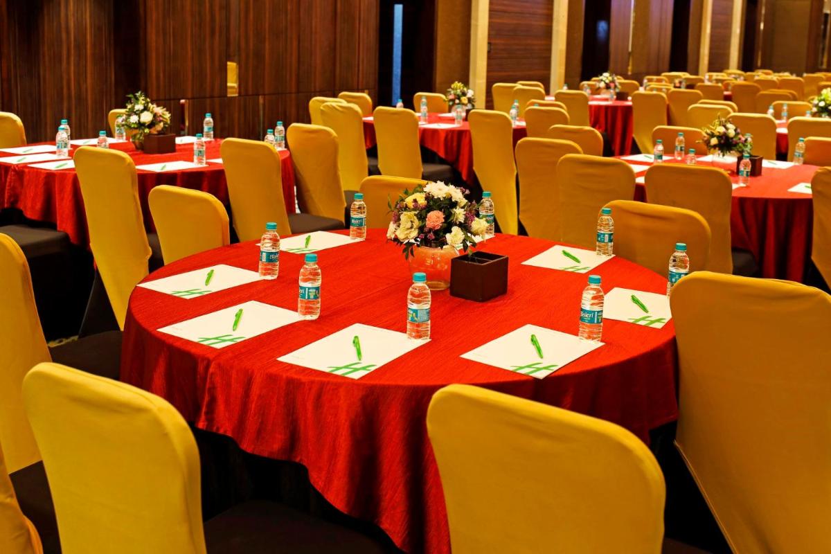 a group of tables with red table cloths and water bottles at Holiday Inn Chennai OMR IT Expressway by IHG in Chennai