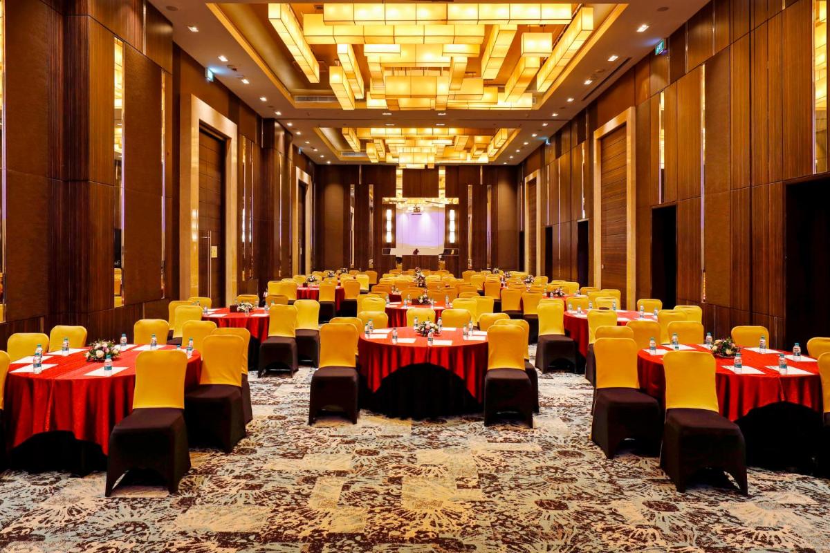 a large banquet hall with tables and yellow chairs at Holiday Inn Chennai OMR IT Expressway by IHG in Chennai