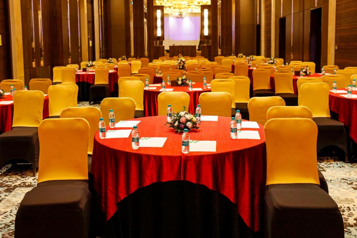 a conference room with red tables and yellow chairs at Holiday Inn Chennai OMR IT Expressway by IHG in Chennai