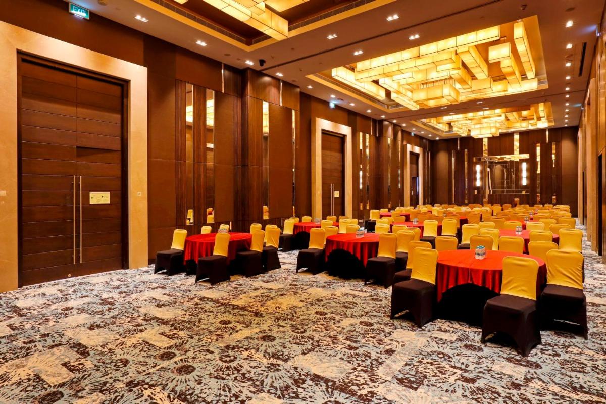 a large room with tables and chairs in it at Holiday Inn Chennai OMR IT Expressway by IHG in Chennai