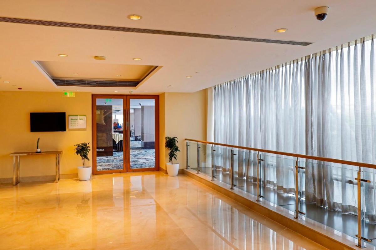 a hallway with a balcony with windows and a door at Holiday Inn Chennai OMR IT Expressway by IHG in Chennai