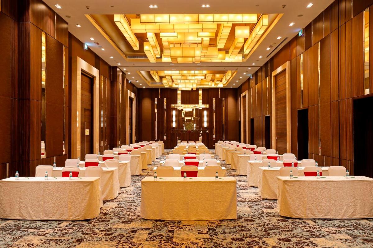a row of tables in a banquet hall at Holiday Inn Chennai OMR IT Expressway by IHG in Chennai