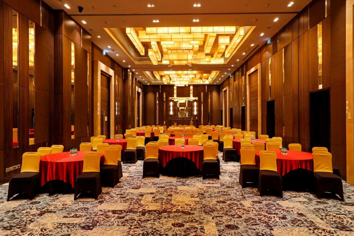 a large room with tables and chairs in it at Holiday Inn Chennai OMR IT Expressway by IHG in Chennai