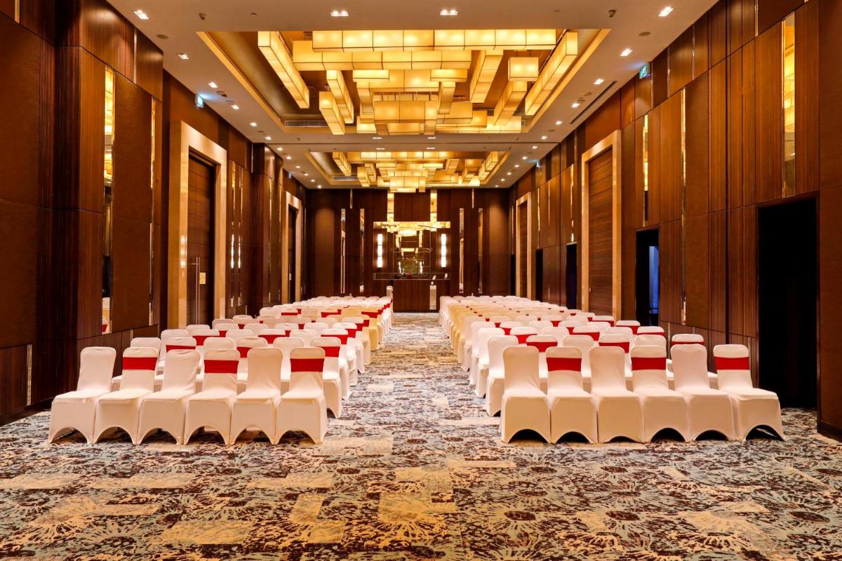 a row of white chairs in a large room at Holiday Inn Chennai OMR IT Expressway by IHG in Chennai