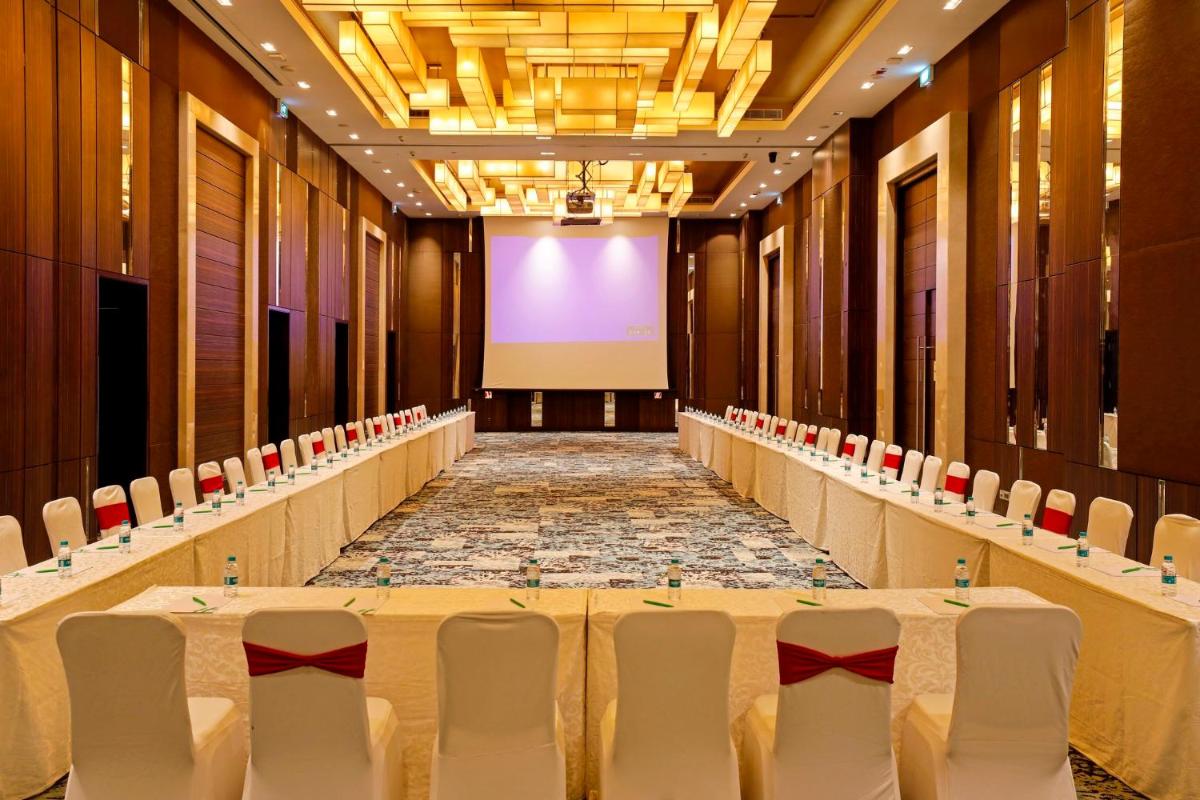 a conference room with a stage and white chairs at Holiday Inn Chennai OMR IT Expressway by IHG in Chennai