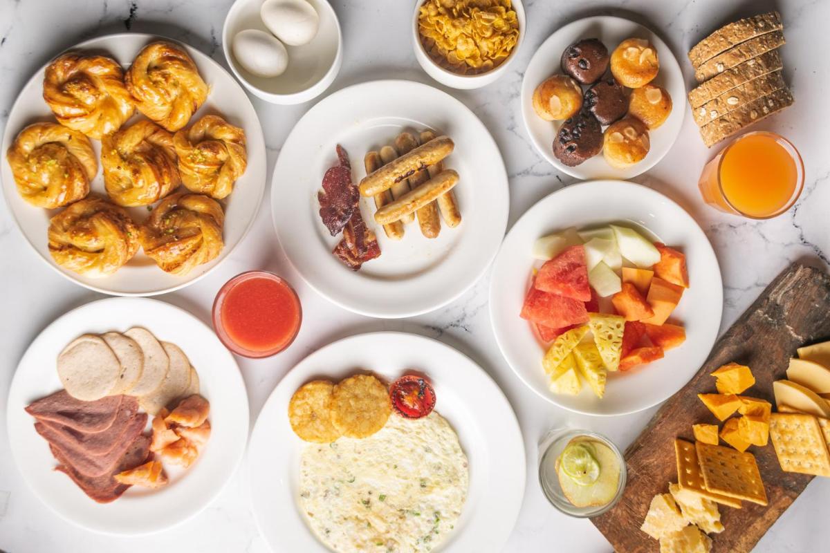 a table with plates of food on it at DoubleTree by Hilton Gurugram Baani Square in Gurgaon
