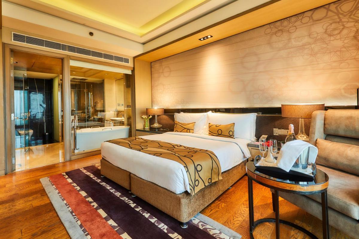 a bedroom with a large bed and a bathroom at Crowne Plaza New Delhi Rohini by IHG in New Delhi a bedroom with a large bed and a bathroom at Crowne Plaza New Delhi Rohini by IHG in New Delhi