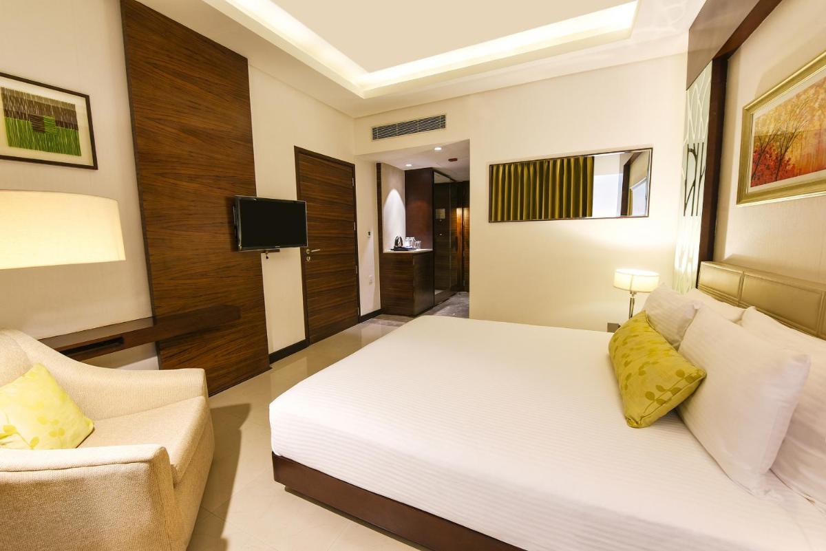 a bedroom with a white bed and a couch at DoubleTree by Hilton Gurugram Baani Square in Gurgaon