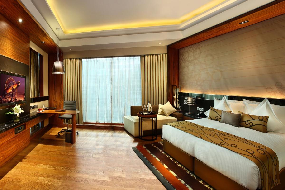 a bedroom with a large bed and a desk at Crowne Plaza New Delhi Rohini by IHG in New Delhi a bedroom with a large bed and a desk at Crowne Plaza New Delhi Rohini by IHG in New Delhi