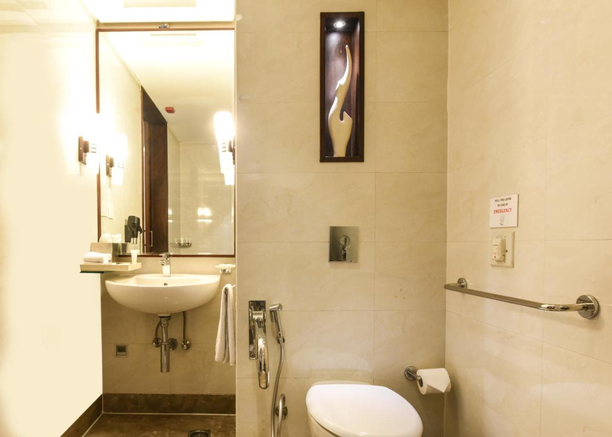 a bathroom with a toilet and a sink at DoubleTree by Hilton Gurugram Baani Square in Gurgaon