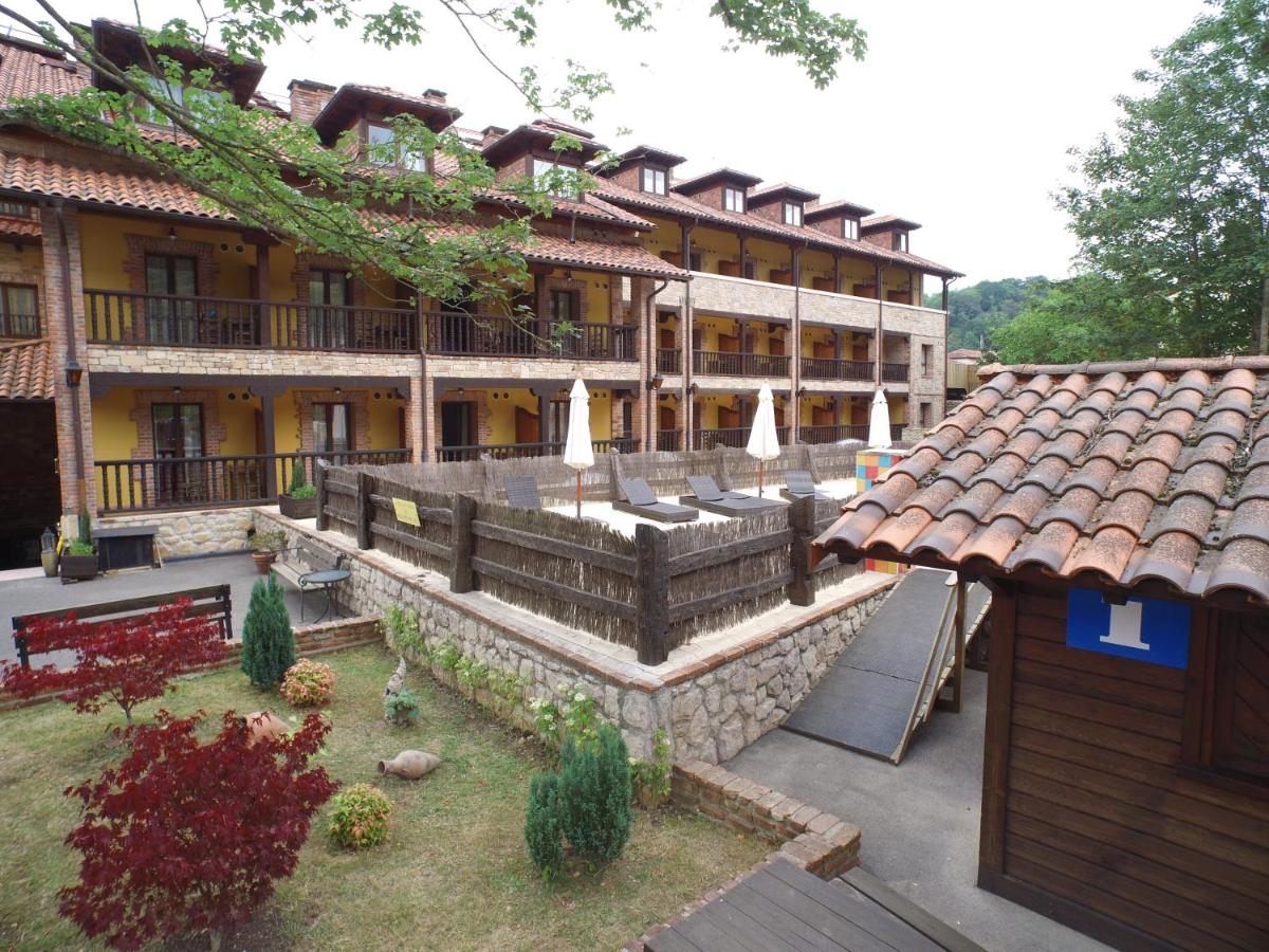 Un gran edificio con un patio y un jardín. en Hotel & Spa María Manuela, en Onís