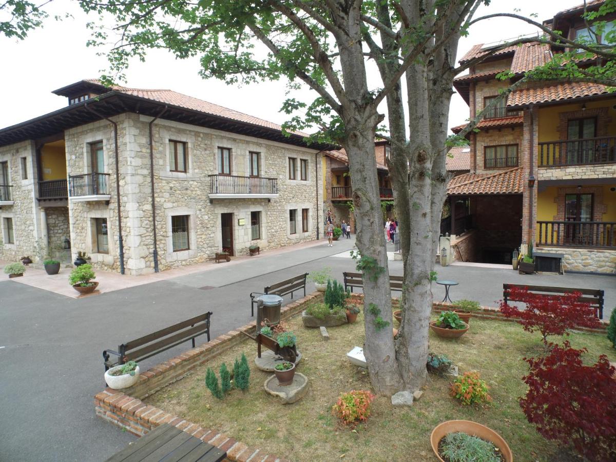 Un parque con bancos y un árbol en un patio. en Hotel & Spa María Manuela, en Onís