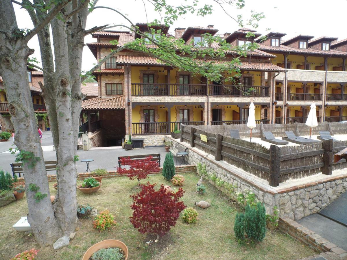 Un gran edificio con un patio delante. en Hotel & Spa María Manuela, en Onís