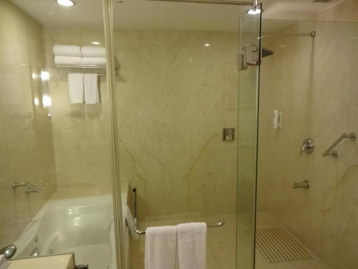 a bathroom with a shower and a tub and a sink at Park Plaza Chennai OMR in Chennai