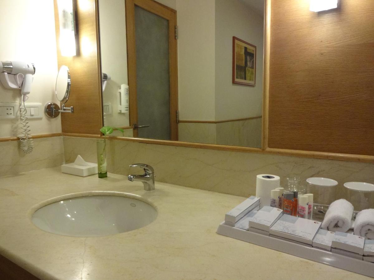 a bathroom counter with a sink and a mirror at Park Plaza Chennai OMR in Chennai