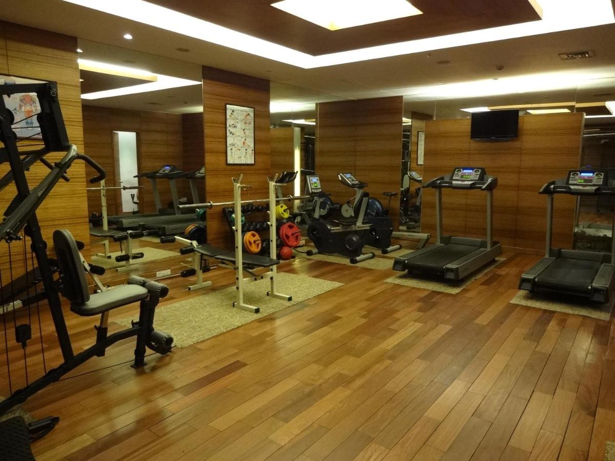 a gym with several treadmills and machines in a room at Park Plaza Chennai OMR in Chennai