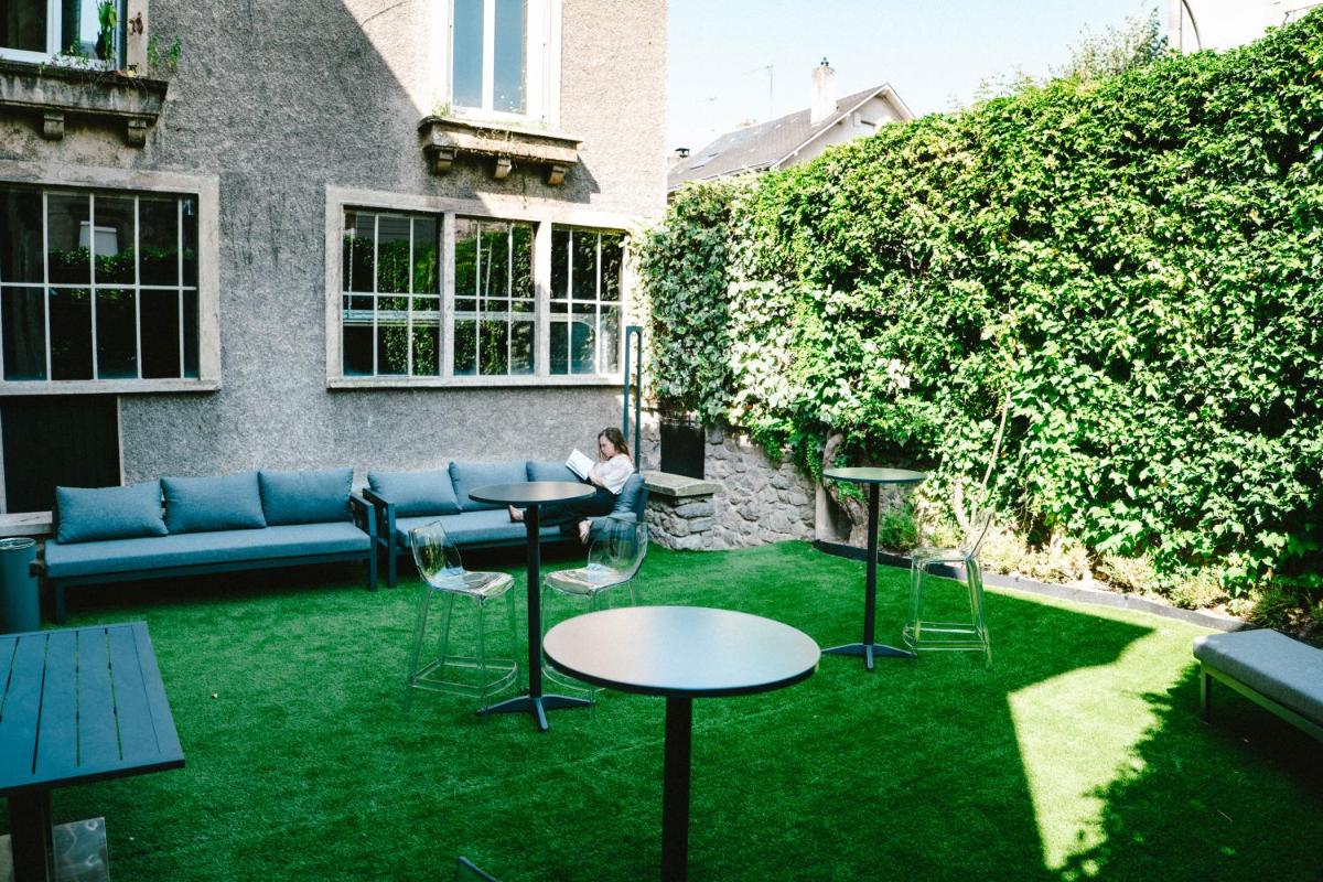 un jardin avec un canapé, des tables et de la pelouse dans l'établissement Villa37, à Limoges