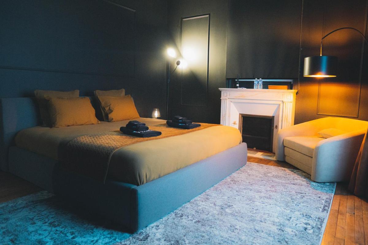 une chambre avec un grand lit et une cheminée dans l'établissement Villa37, à Limoges