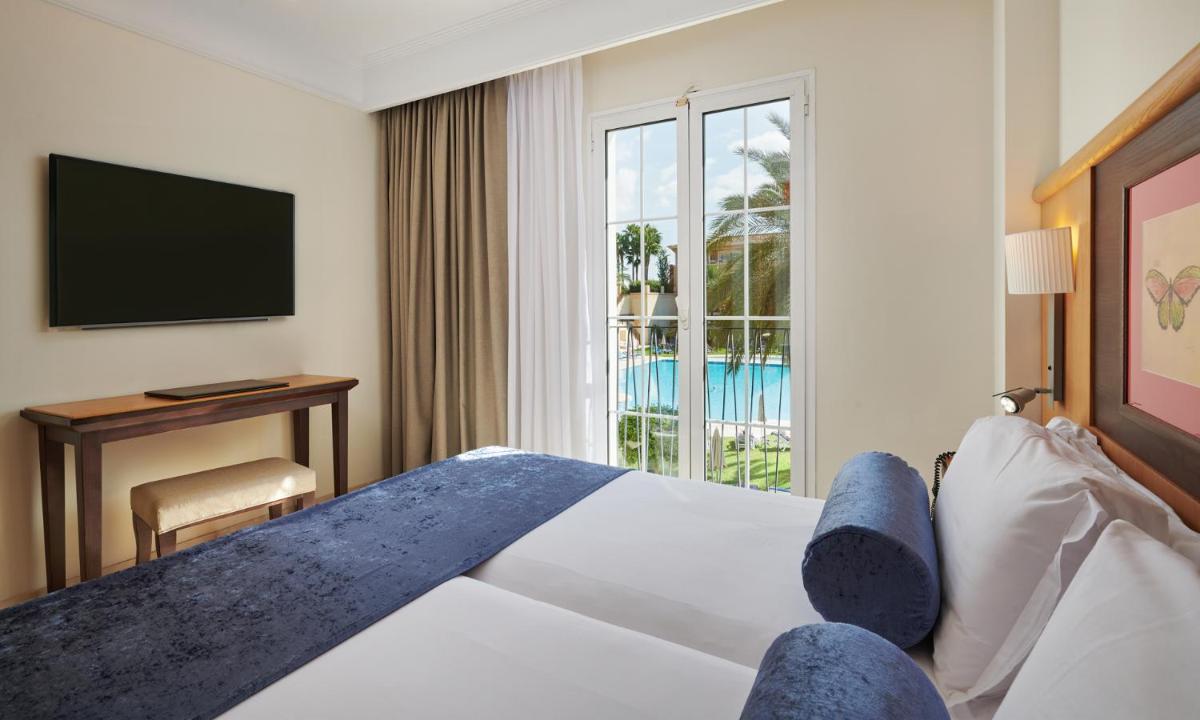 una habitación de hotel con una cama y un televisor en Grupotel Playa de Palma Suites & Spa, en Playa de Palma