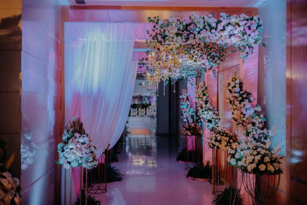 a corridor with white and pink flowers and curtains at Radisson Blu Hotel Pune Kharadi in Pune