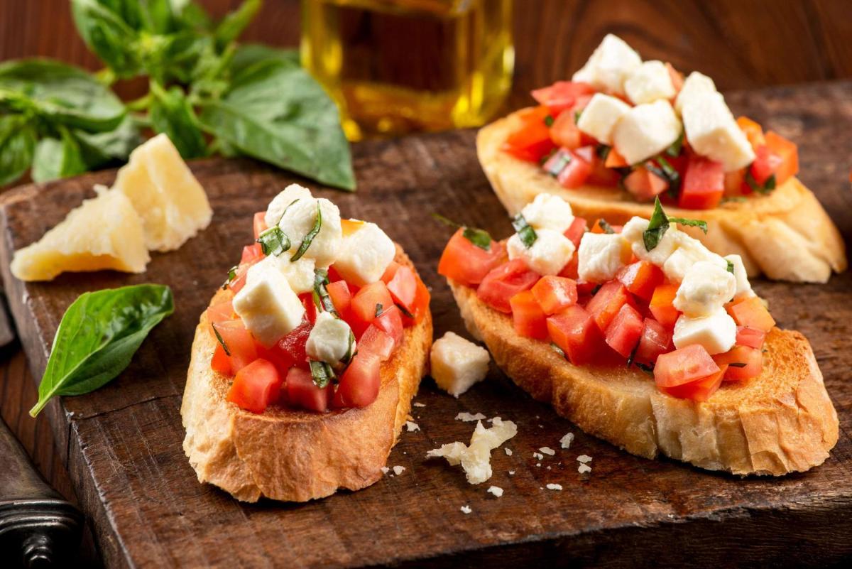 three pizzas with tomatoes and cheese on a cutting board at Radisson Blu Plaza Delhi Airport in New Delhi three pizzas with tomatoes and cheese on a cutting board at Radisson Blu Plaza Delhi Airport in New Delhi