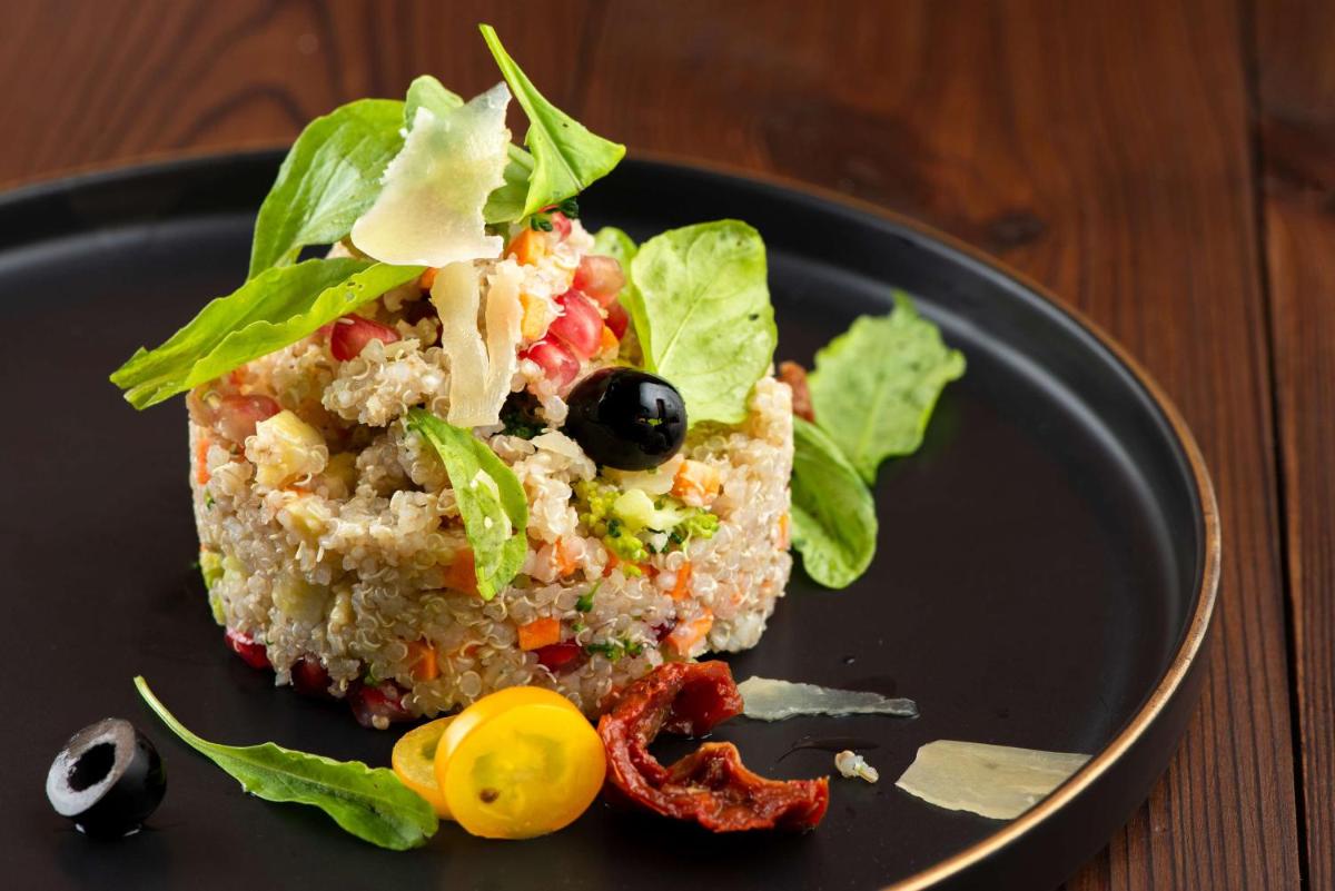 a piece of food on a black plate with lettuce at Radisson Blu Plaza Delhi Airport in New Delhi a piece of food on a black plate with lettuce at Radisson Blu Plaza Delhi Airport in New Delhi
