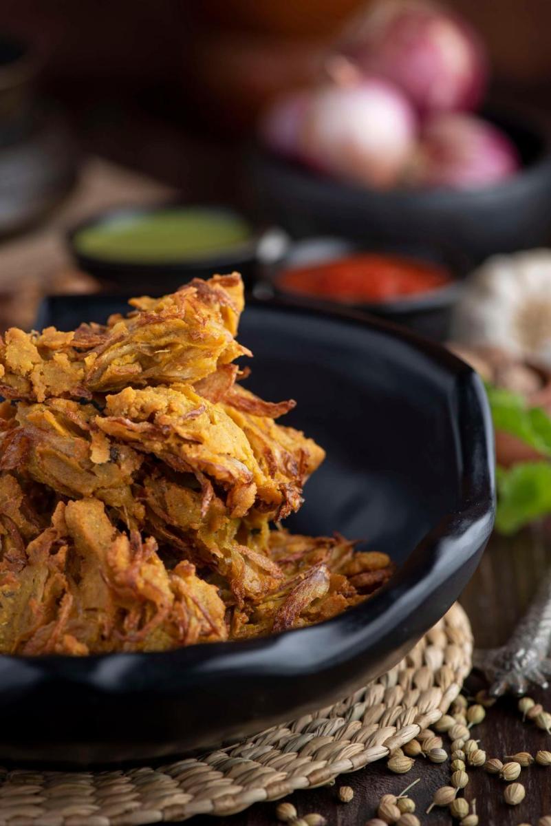 a black bowl filled with food on a table at Radisson Blu Plaza Delhi Airport in New Delhi a black bowl filled with food on a table at Radisson Blu Plaza Delhi Airport in New Delhi