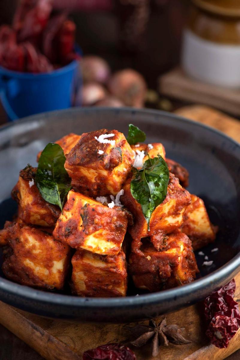 a plate of food on a wooden table at Radisson Blu Plaza Delhi Airport in New Delhi a plate of food on a wooden table at Radisson Blu Plaza Delhi Airport in New Delhi