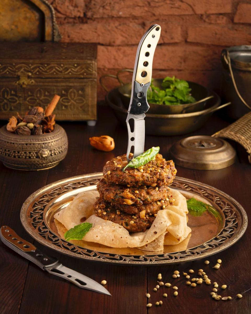 a plate of food with a steak on a table with a knife at Radisson Blu Plaza Delhi Airport in New Delhi a plate of food with a steak on a table with a knife at Radisson Blu Plaza Delhi Airport in New Delhi