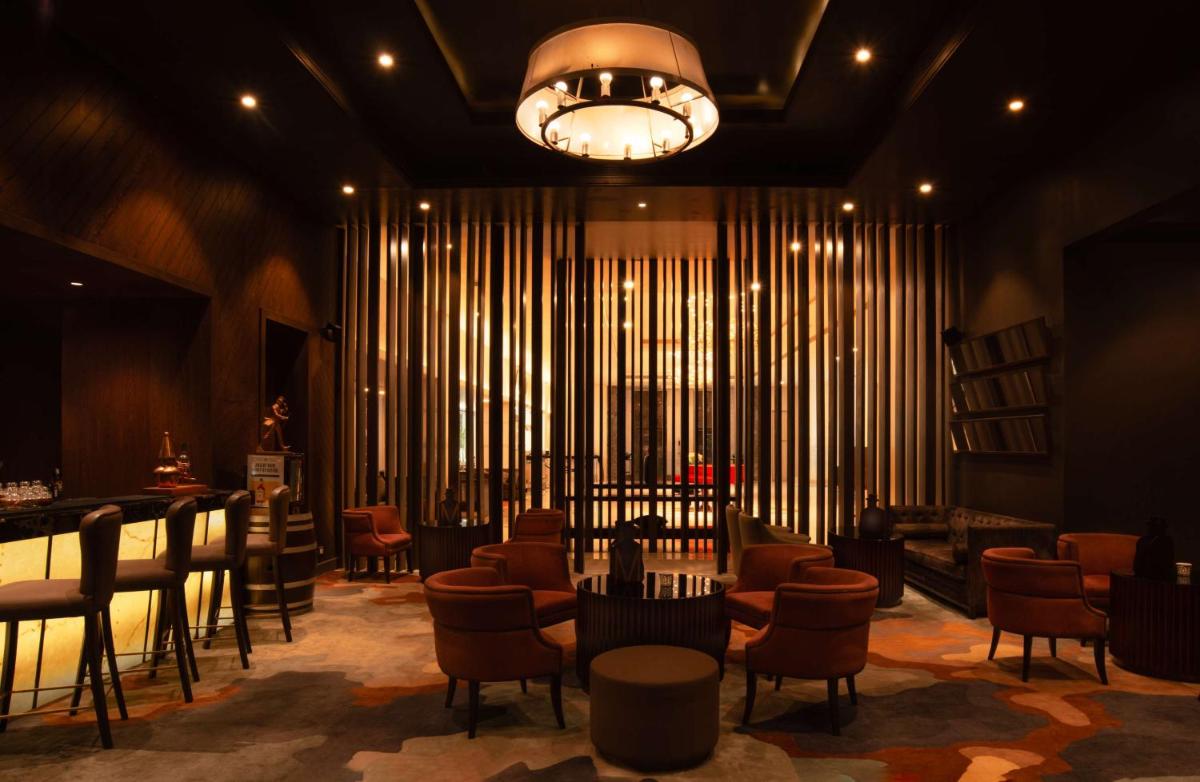 a lobby with a waiting room with chairs and a chandelier at Radisson Blu Bengaluru Outer Ring Road in Bengaluru