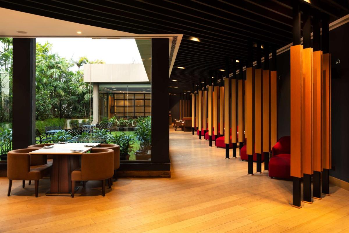 a dining room with a table and chairs at Radisson Blu Bengaluru Outer Ring Road in Bengaluru