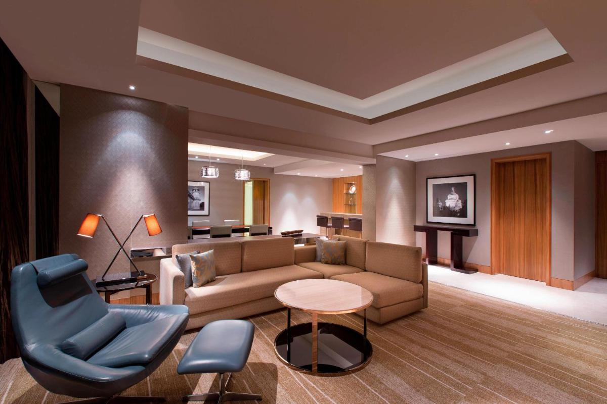 a living room with a couch and a table and chairs at Sheraton Grand Bangalore Hotel at Brigade Gateway in Bengaluru