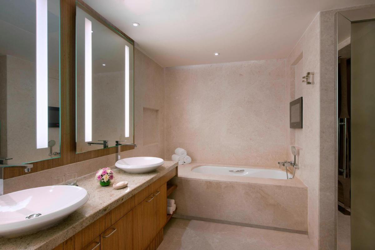 a bathroom with two sinks and a bath tub at Sheraton Grand Bangalore Hotel at Brigade Gateway in Bengaluru