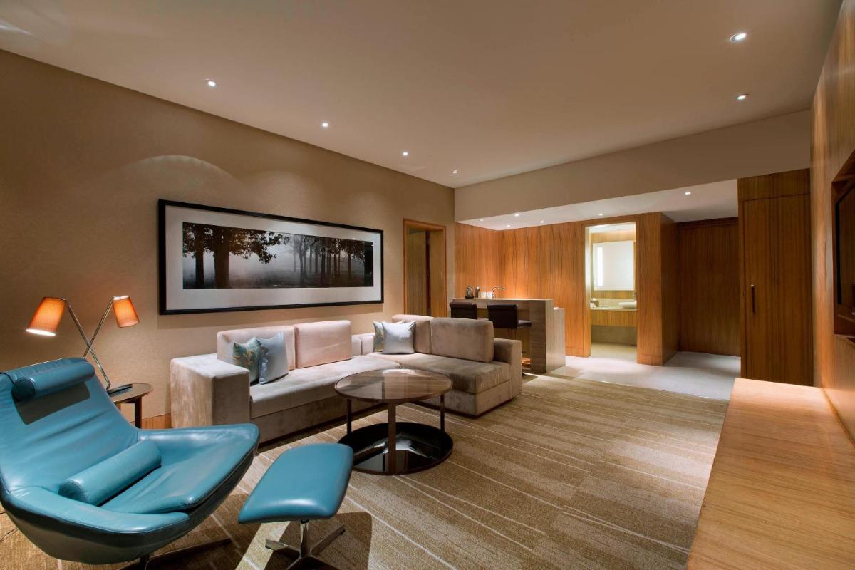 a living room with a couch and a chair at Sheraton Grand Bangalore Hotel at Brigade Gateway in Bengaluru