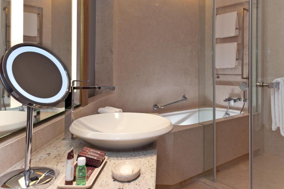 a bathroom with a sink and a mirror and a shower at Sheraton Grand Bangalore Hotel at Brigade Gateway in Bengaluru