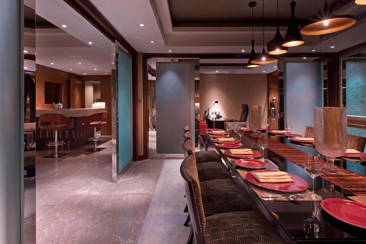 a dining room with a long table with red plates at Sheraton Grand Bangalore Hotel at Brigade Gateway in Bengaluru