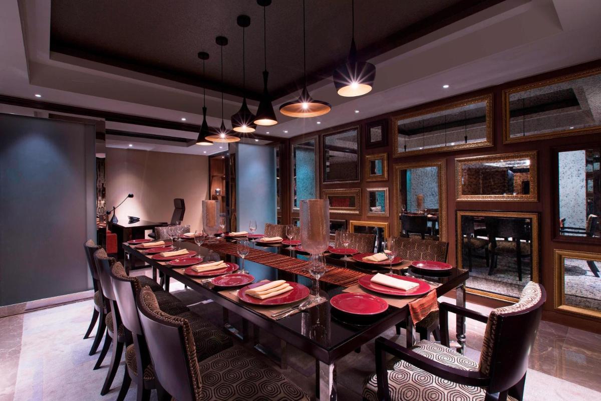 a large dining room with a long table and chairs at Sheraton Grand Bangalore Hotel at Brigade Gateway in Bengaluru