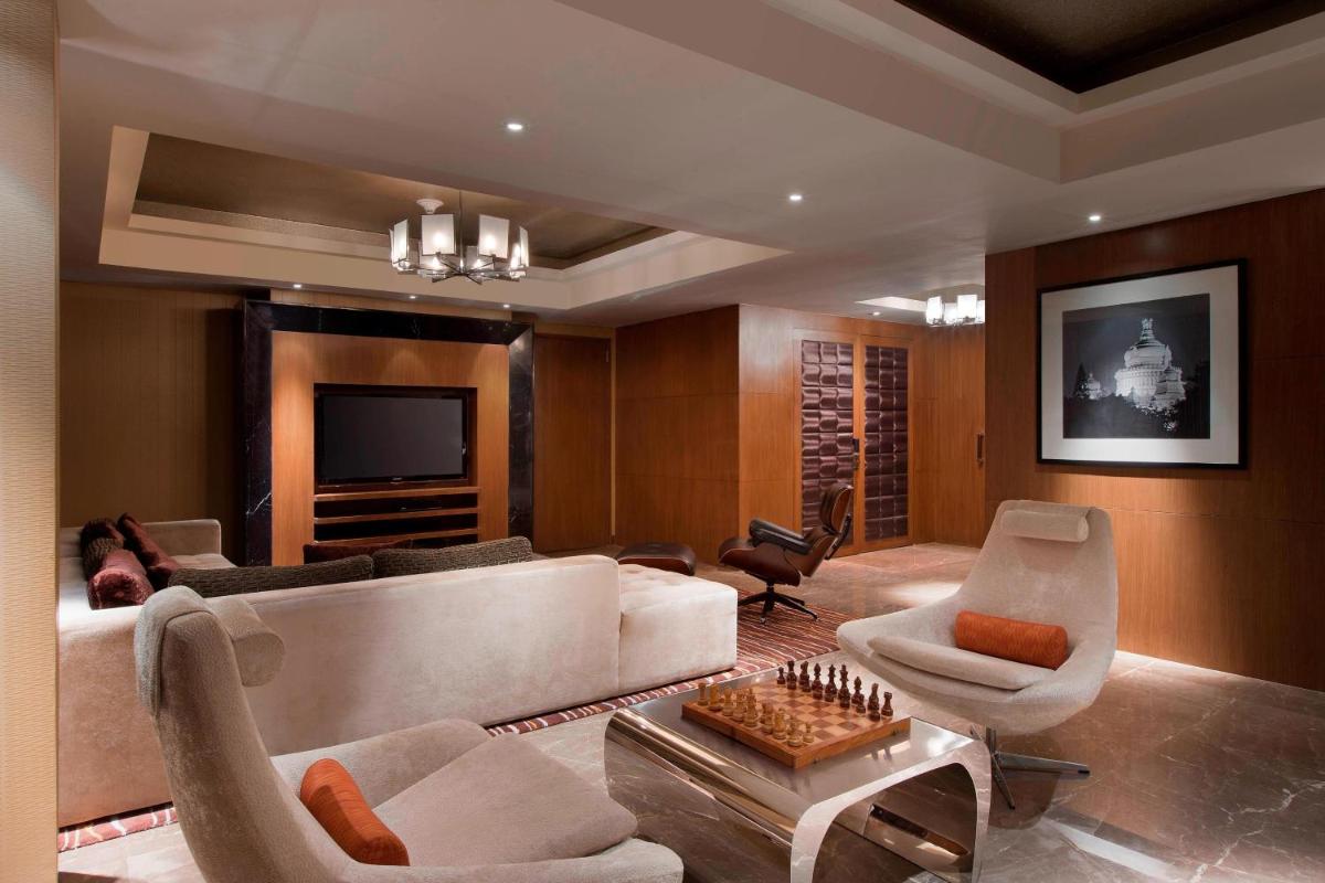 a living room with a couch and chairs and a television at Sheraton Grand Bangalore Hotel at Brigade Gateway in Bengaluru
