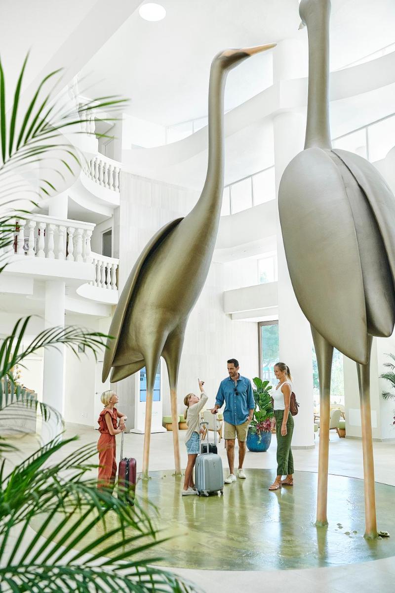 Un grupo de personas de pie junto a una estatua de un pájaro. en Iberostar Selection Albufera Park All Inclusive, en Playa de Muro 107 fotos más
