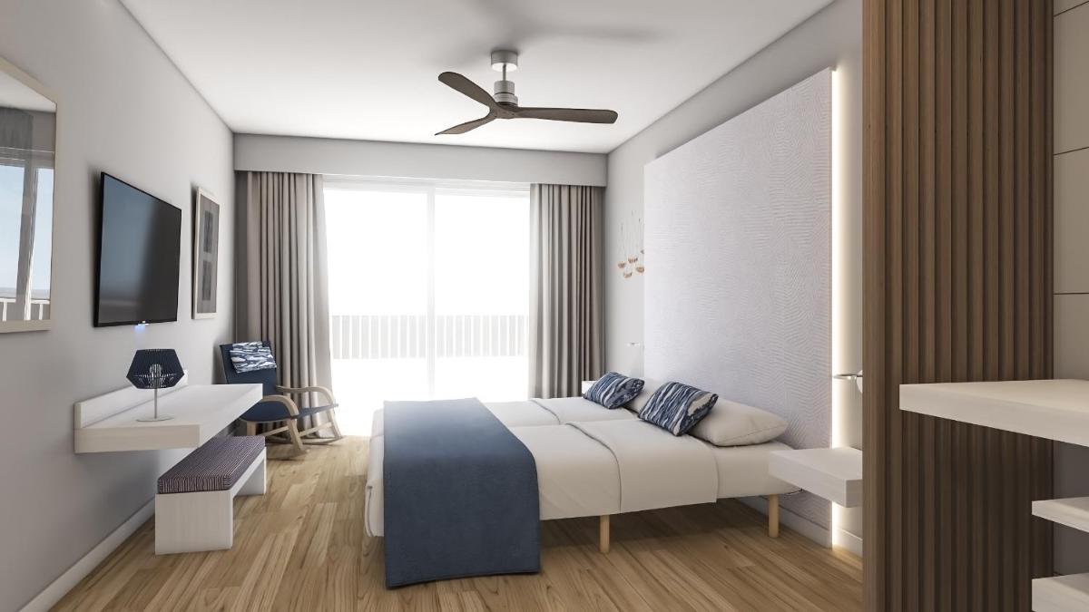 Un dormitorio con una cama y un ventilador de techo. en Blau Punta Reina, en Cala Mendia