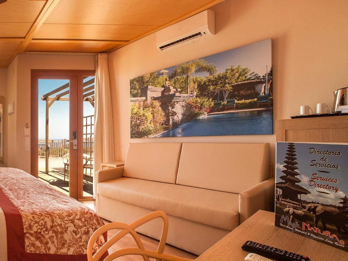 1 dormitorio con sofá y una gran pintura en la pared en Magic Natura Resort, en Benidorm