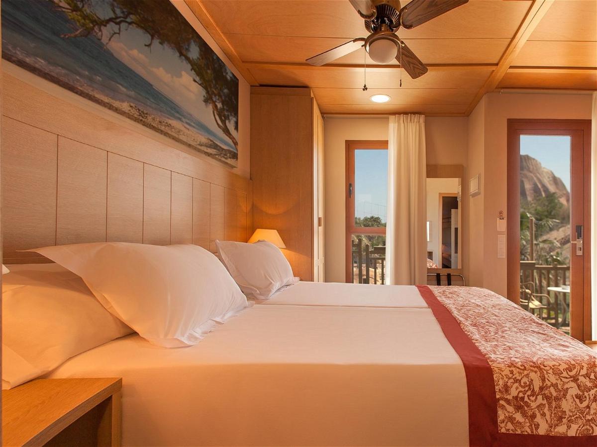 Un dormitorio con una cama con ventilador de techo. en Magic Natura Resort, en Benidorm 180 fotos más