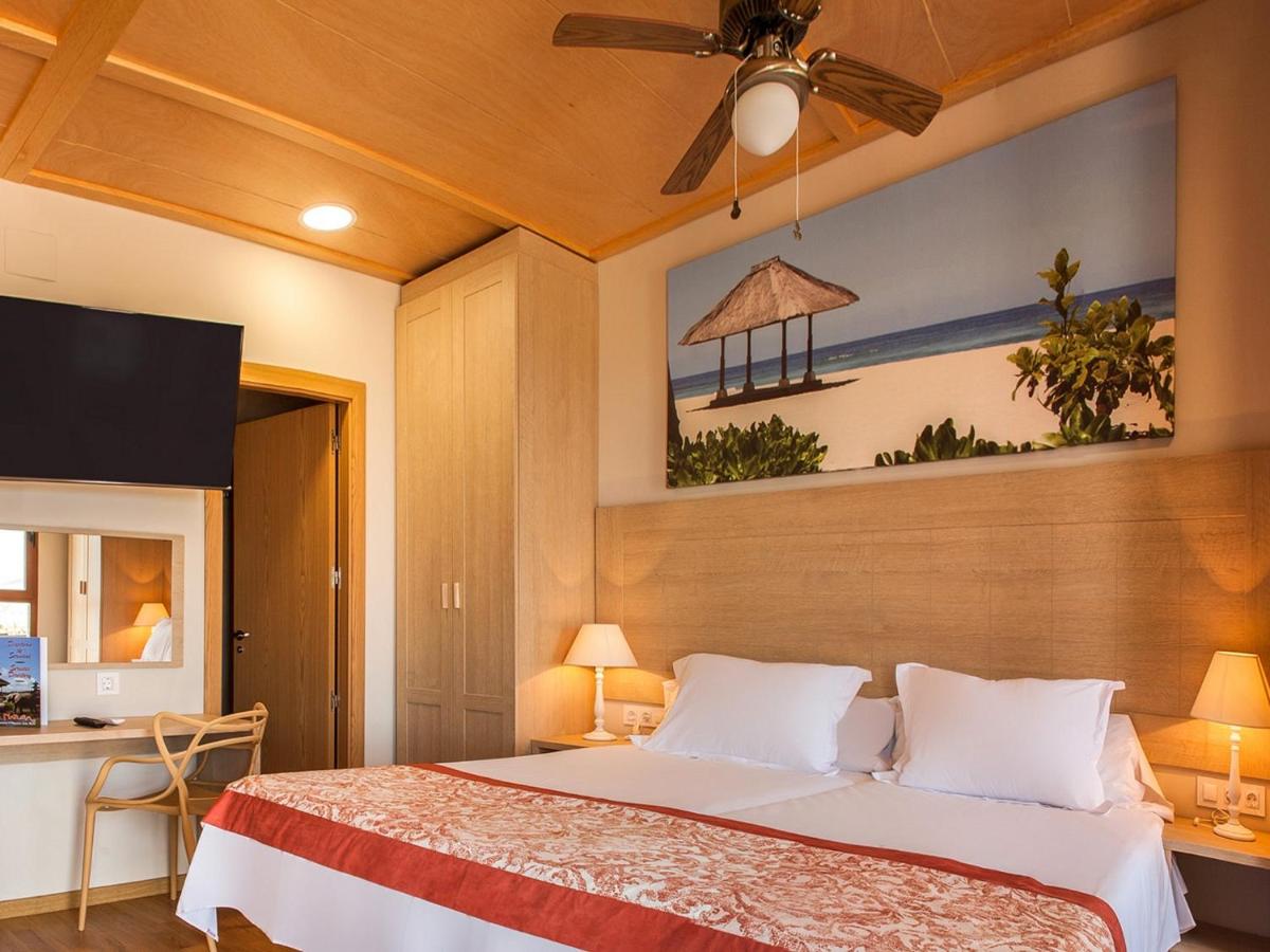Un dormitorio con una cama con ventilador de techo. en Magic Natura Resort, en Benidorm