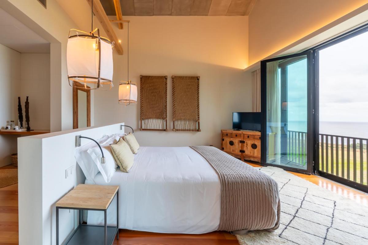 um quarto com uma cama e uma varanda em SENSI Azores Nature and SPA em Ginetes