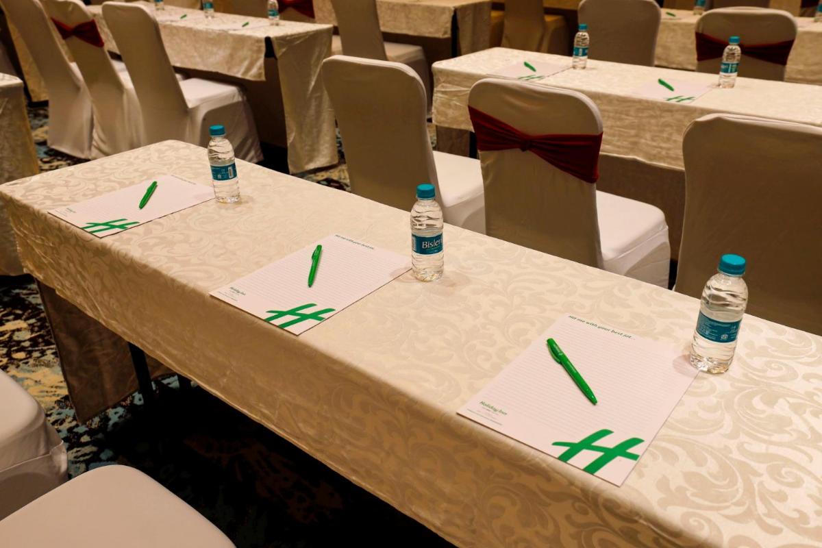 two bottles of water sitting on top of tables at Holiday Inn Chennai OMR IT Expressway by IHG in Chennai