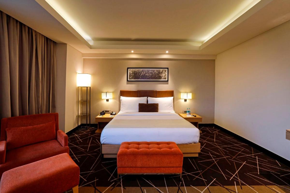 a hotel room with a bed and a chair at Holiday Inn Chennai OMR IT Expressway by IHG in Chennai