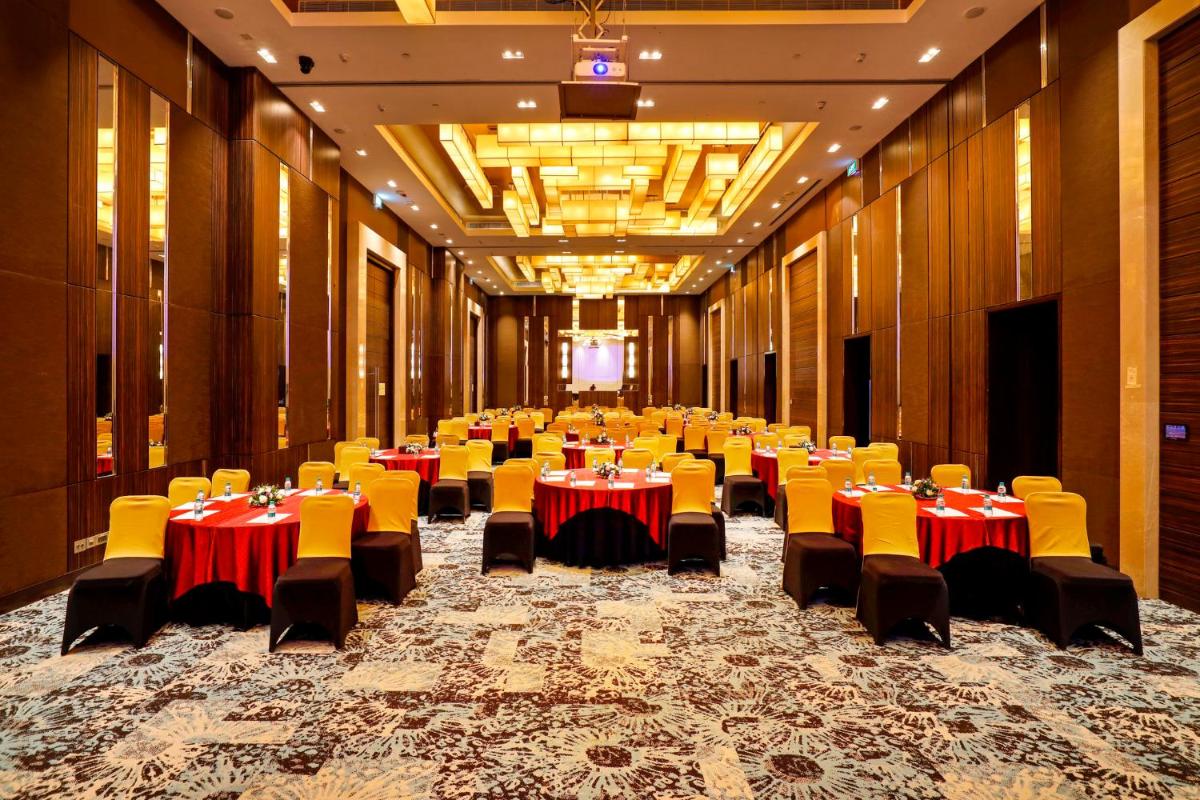 a large banquet hall with tables and yellow chairs at Holiday Inn Chennai OMR IT Expressway by IHG in Chennai