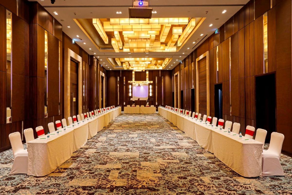 a hallway with chairs and a long aisle at Holiday Inn Chennai OMR IT Expressway by IHG in Chennai